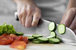 A chef cutting vegetables on a cutting board