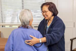a caregiver checking heart rate of a resident at Aviara Healthcare