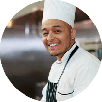 smiling chef wearing a chef's hat and an apron