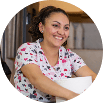 smiling woman holding cleaning supplie